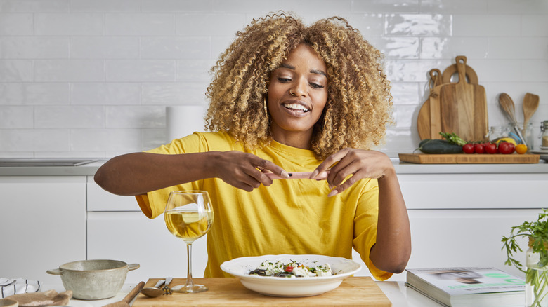 Individual eating a bowl of pasta