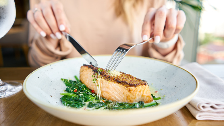 Image of a person eating salmon and spinach