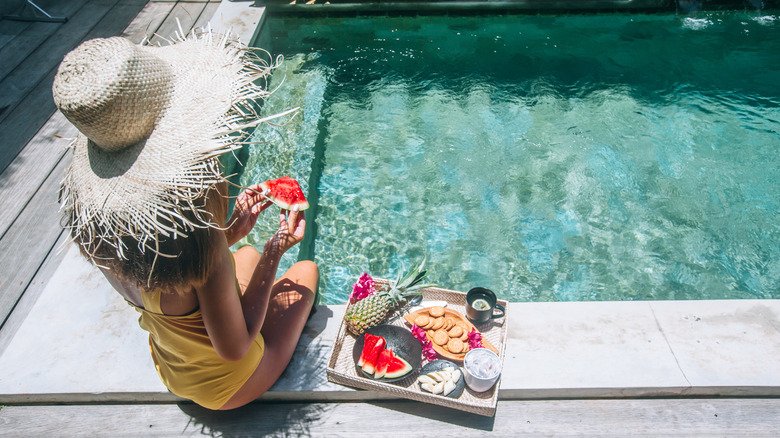 Girl eats healthy foods by the pool