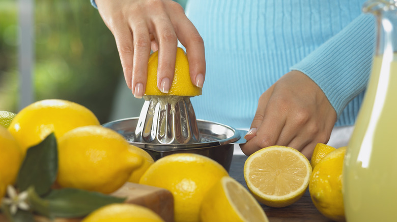 woman's hand juicing lemons