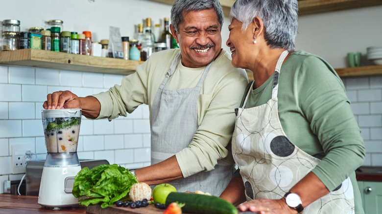 mature couple preparing healthy smoothie