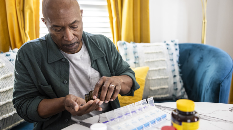 man sorting out his medications and supplements