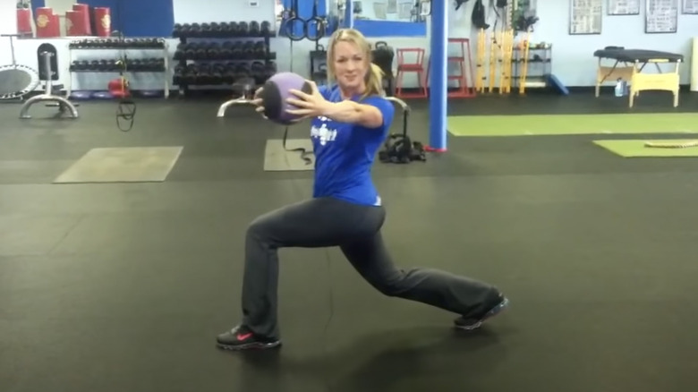 woman doing forward lunge with rotation
