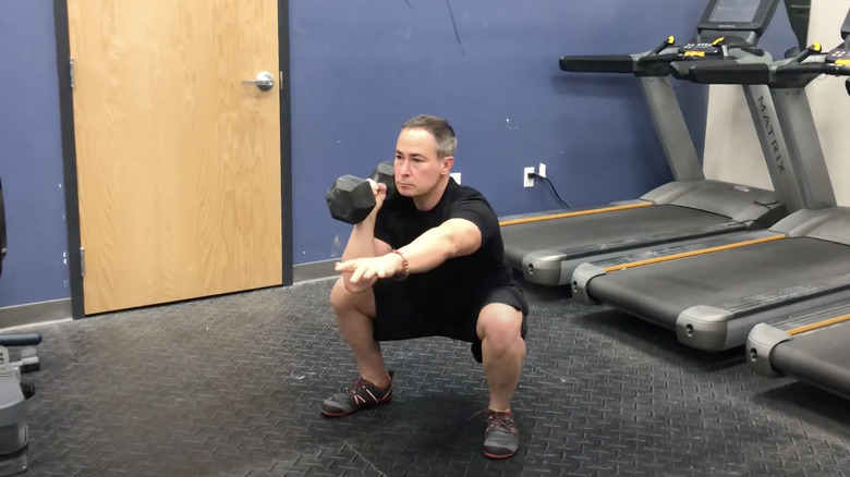 man doing offset dumbbell squat