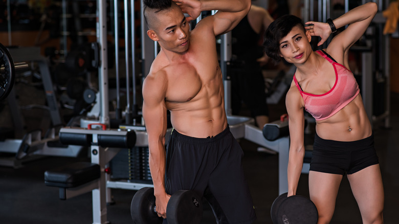 couple doing dumbbell side bends