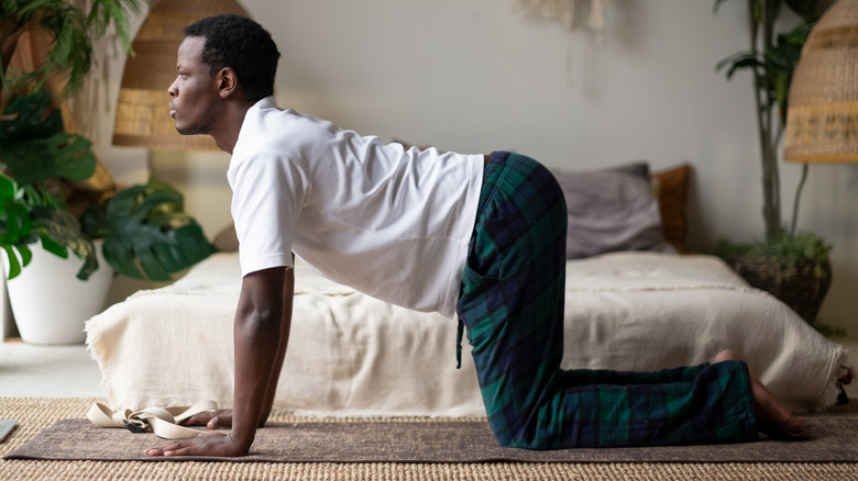 Man performing the Cat-Cow yoga pose