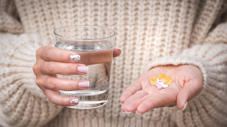 woman holding supplements in hand