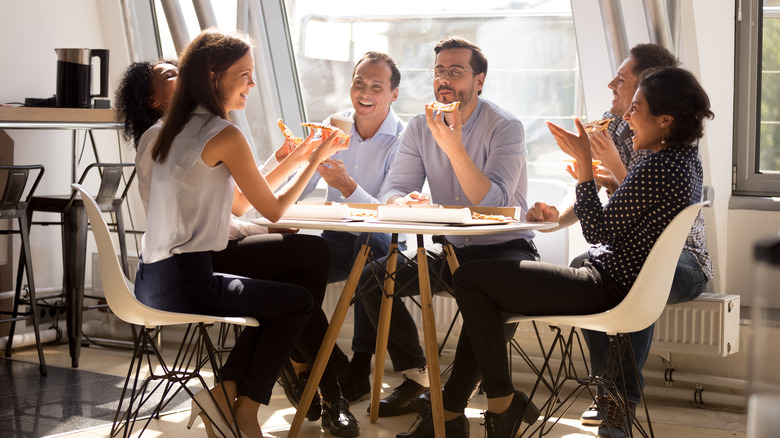 Happy co-workers sharing a pizza 