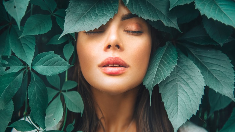 woman standing in cbd leaves feeling zen