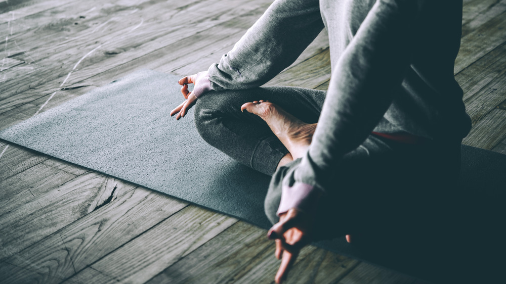 Woman meditating on yoga mat 