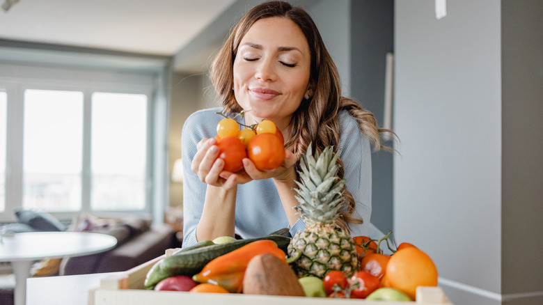 woman holding fresh fruits and vegetables