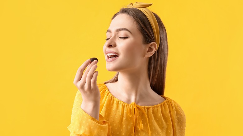 woman eating a piece of dark chocolate