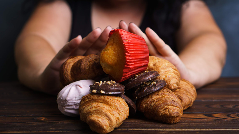 Woman pushing away pastries