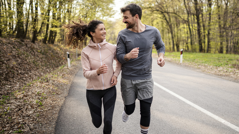 Smiling couple jogging outdoors