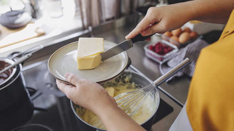 Adding a slice of butter to pot