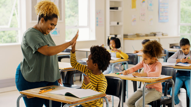 Teacher giving a high-five to student for good behavior