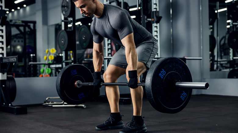 Man performing deadlift inside gym