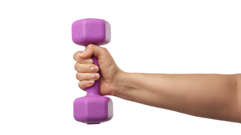Woman's hand holding small dumbbell