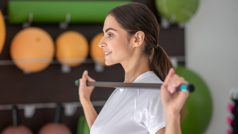 Woman using stick to stretch shoulders