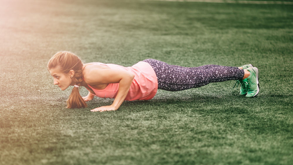 woman doing push up in the grass
