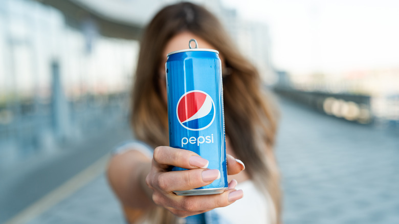 Someone holds a can of Pepsi