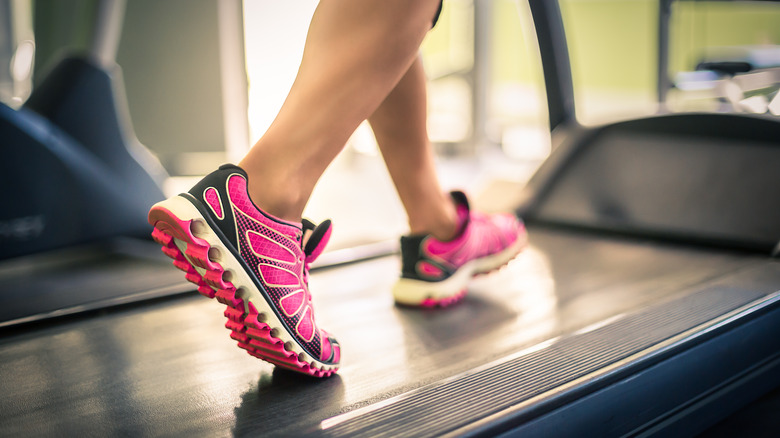 Woman wearing running shoes while on treadmill