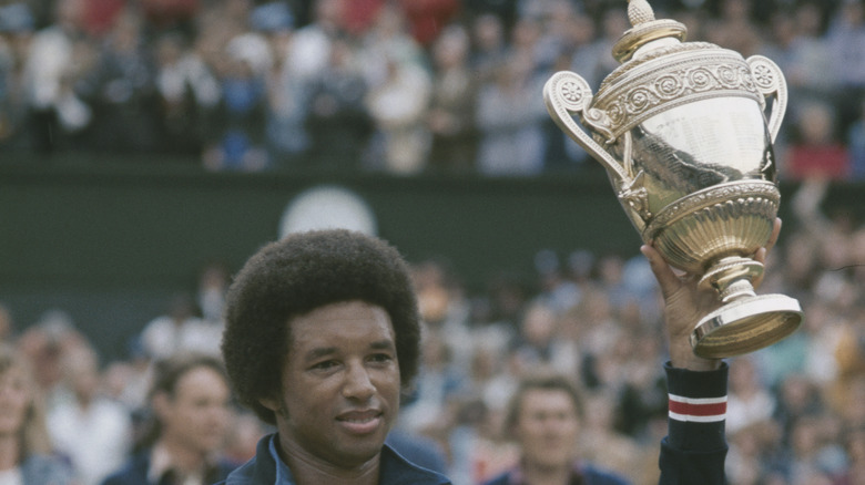 Arthur Ashe holding the Wimbledon trophy