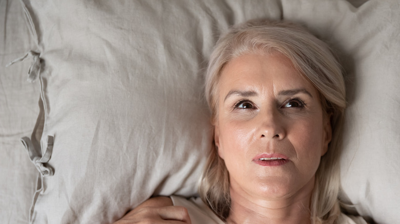 woman laying in bed nervous