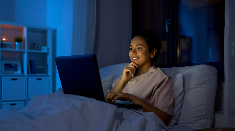 woman sitting up in bed on her laptop