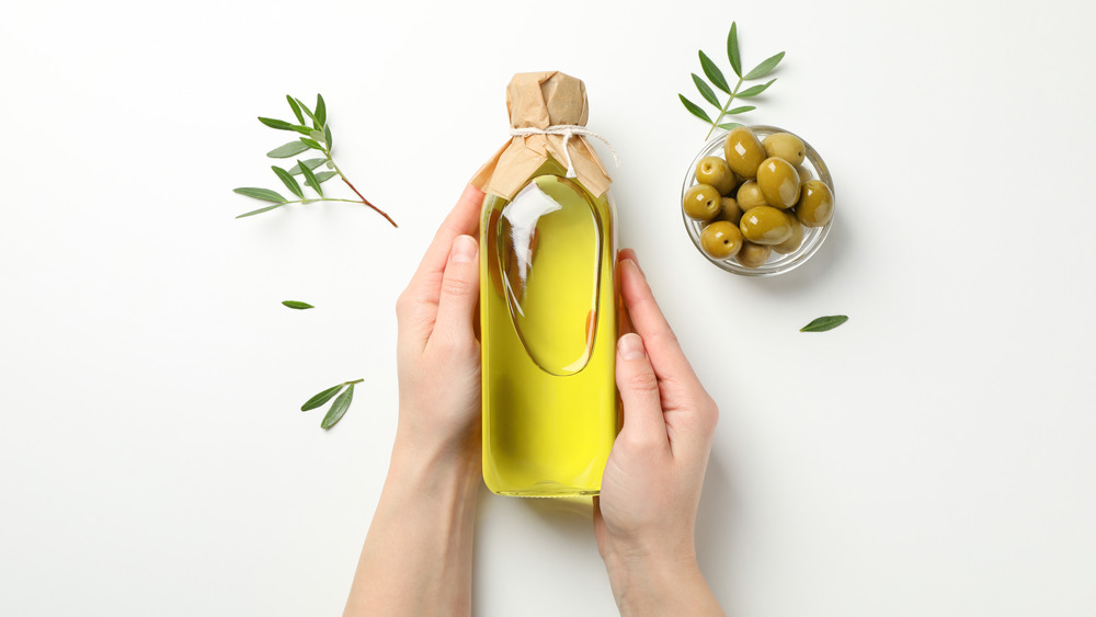 hands holding bottle of olive oil