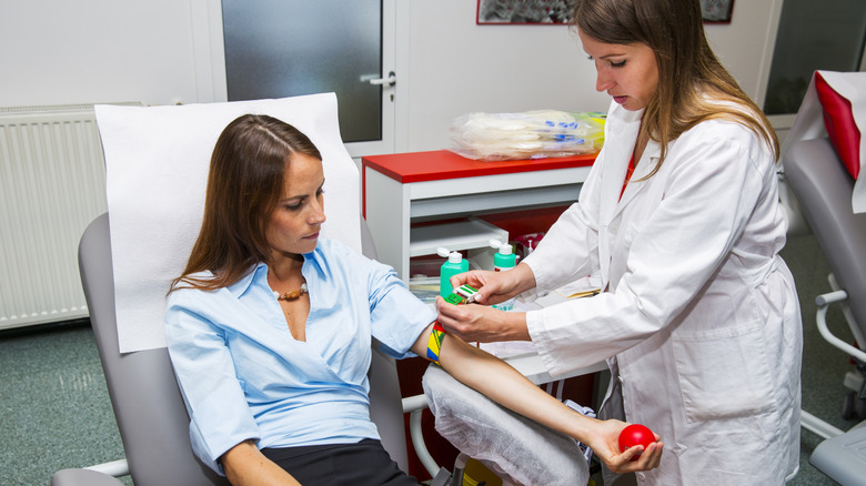 A woman extending her arm while donating blood