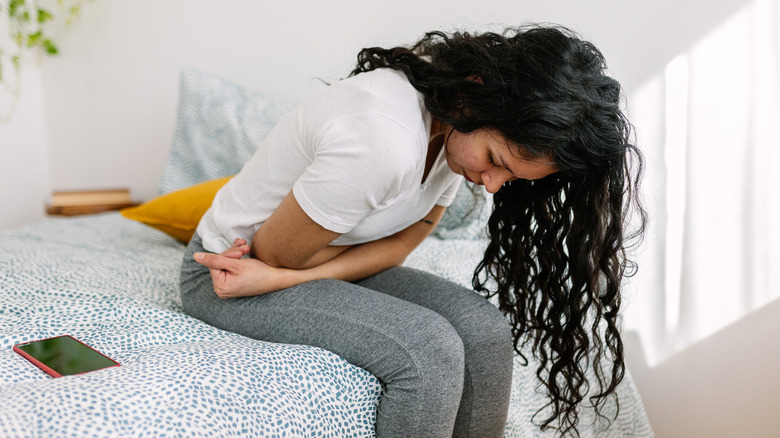 A woman folded over holding her stomach