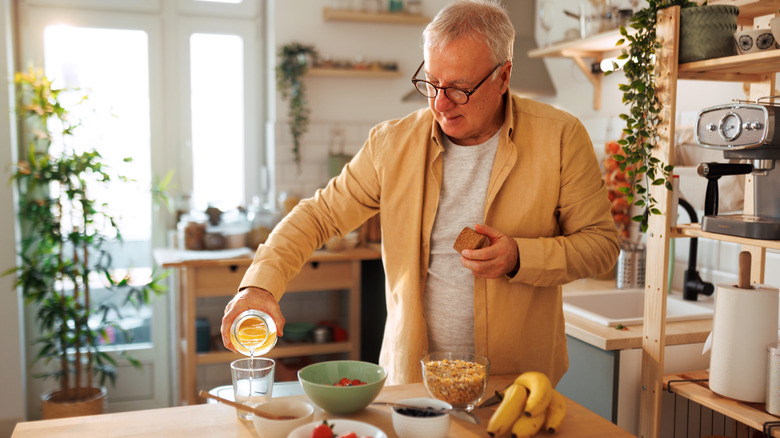 man pouring juice, making healthy breakfast