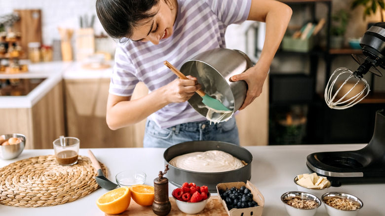 scraping batter out of mixing bowl