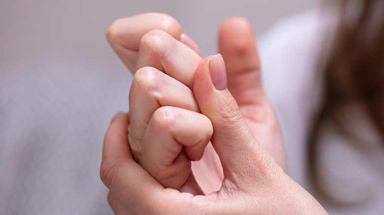 Woman cracking their knuckles