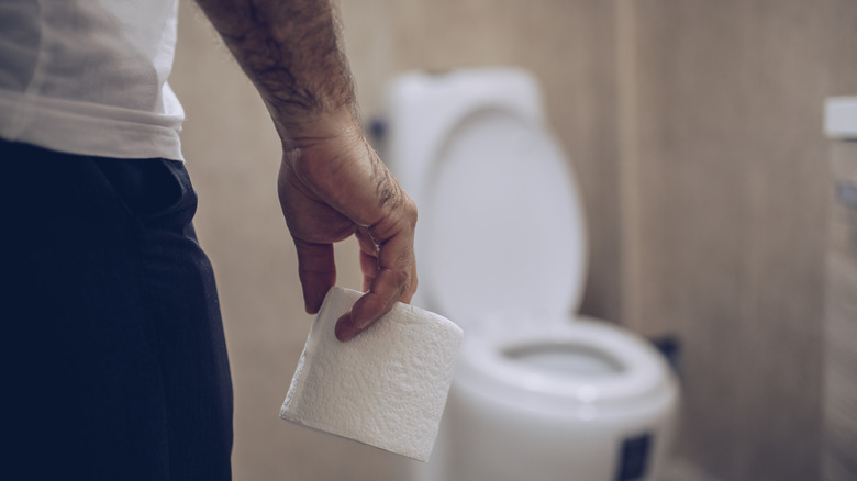 Man holding toilet paper roll 