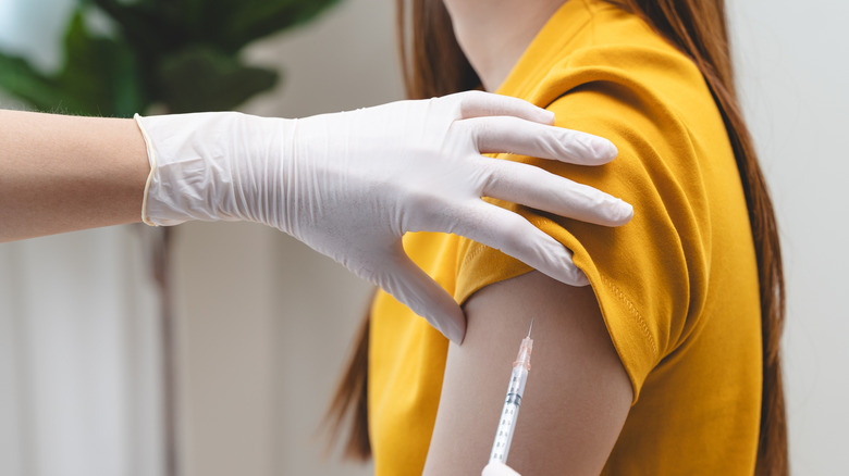 A woman's arm receiving a vaccine