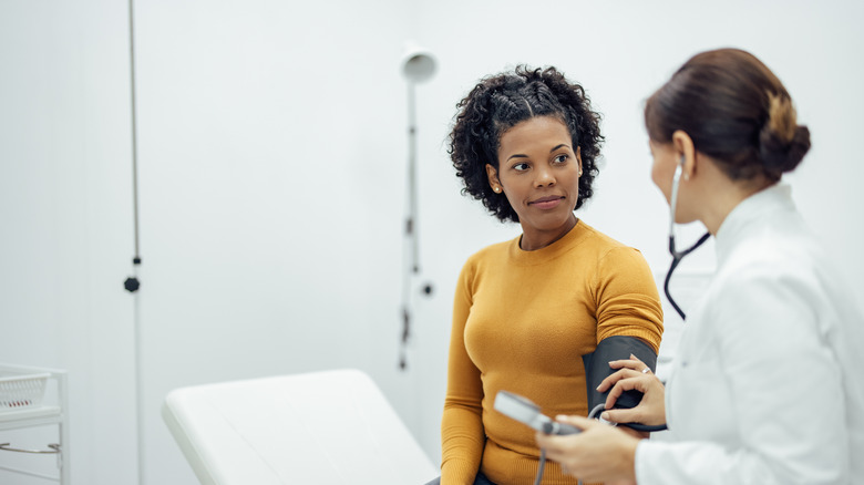 doctor measuring blood pressure of a woman