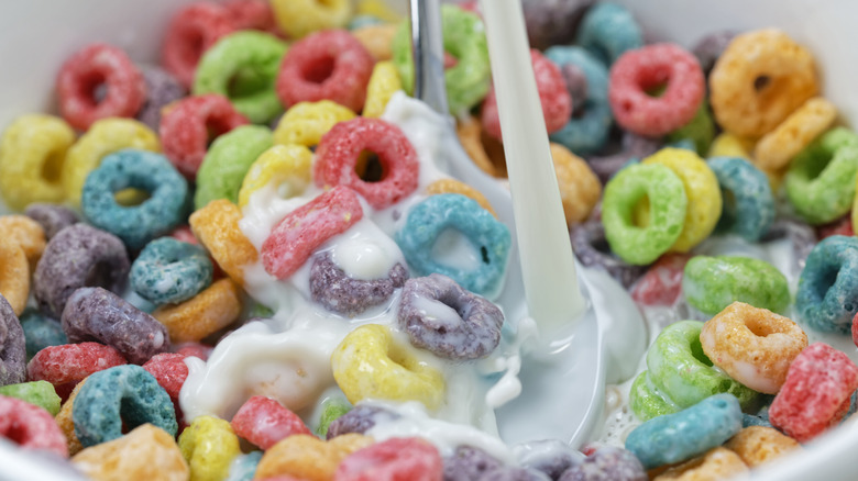 A stream of milk pouring over Froot Loops cereal