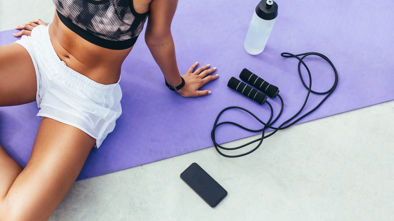 An athlete sits next to a jump rope