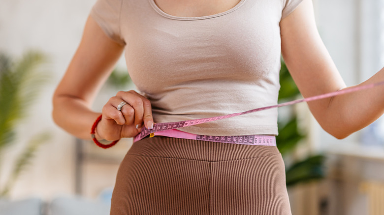 woman's torso wrapped in measuring tape