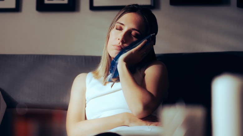 woman putting ice pack on her jaw