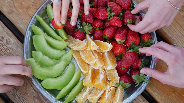 People eat a bowl of fruit