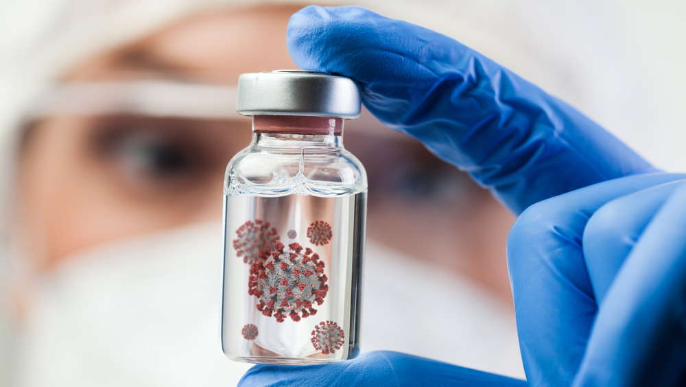 scientist holding vial with coronavirus