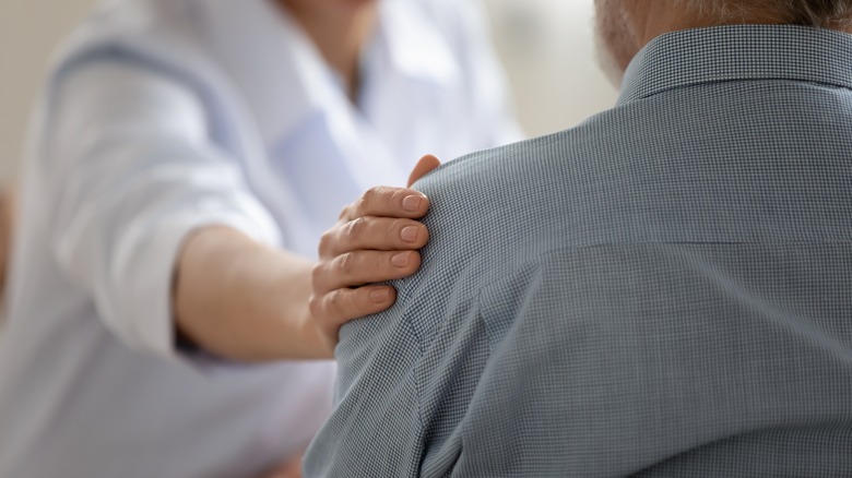 doctor with comforting hand on patient shoulder