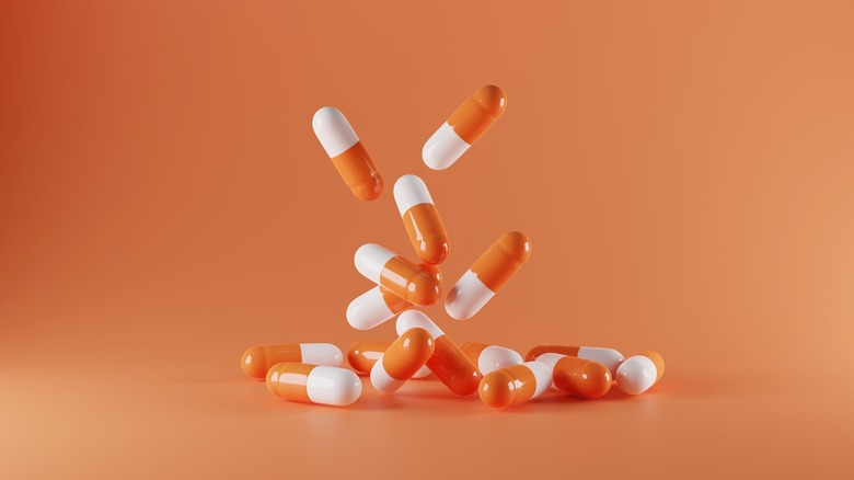 capsule pills against an orange background