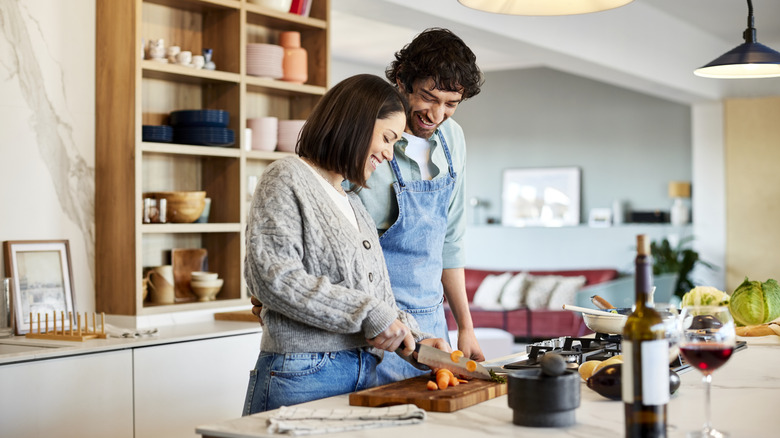 A couple cooking dinner in their kitchen