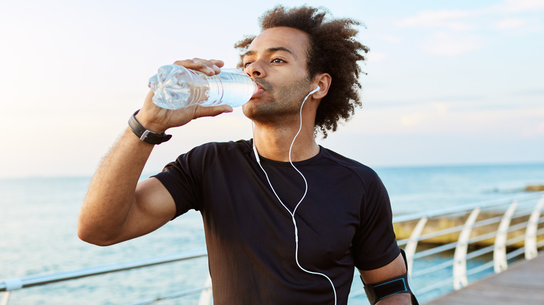 man drinking from water bottle