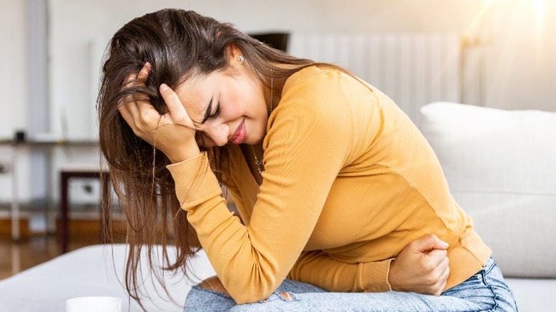 Woman sitting with stomach cramps