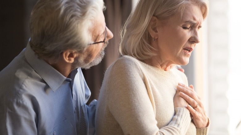 Older woman grabbing chest